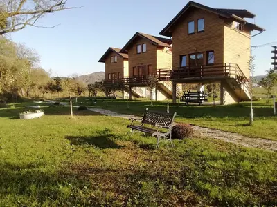 a wooden house with a bench in front of it at Holiday homes Piralo in Kostajnica