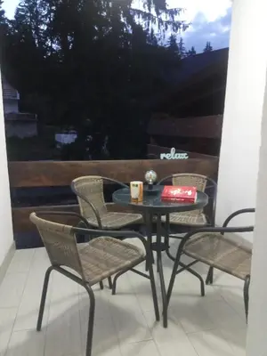 a table and chairs on a balcony with a coffee cup and a book at Apartments Žera in Vlasic