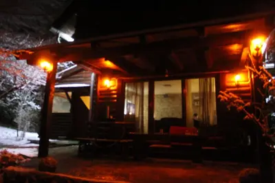 a wooden cabin with a porch at night at Jajce,Plivsko jezero in Jajce