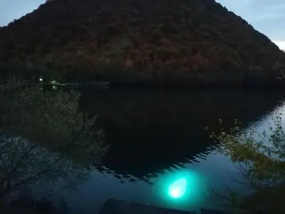 a view of a lake at night with a green light at Jajce,Plivsko jezero in Jajce