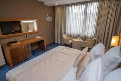 a hotel room with a large bed and a television at Hotel Dubrovnik in Zenica