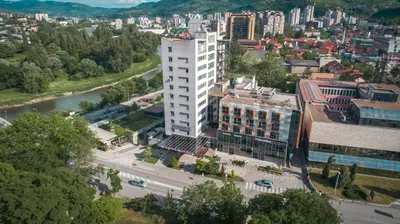 an aerial view of a city with a tall white building at Hotel Dubrovnik in Zenica