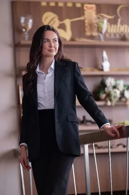 a woman in a suit leaning on a rail with a suitcase at Hotel Dubrovnik in Zenica