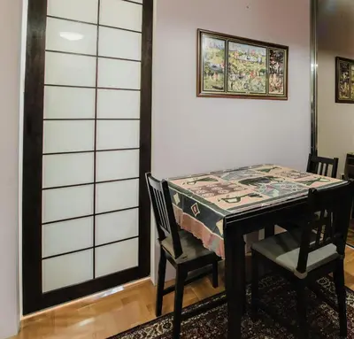 a dining room table with two chairs and a table with a table cloth at City Center Apartment with parking in Banja Luka