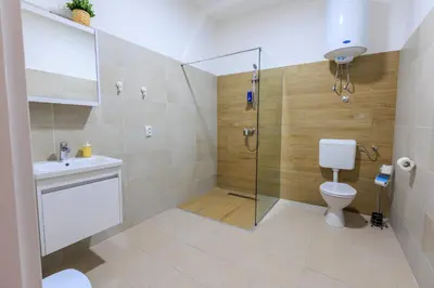 a bathroom with a shower and a toilet and a sink at Apartmani i sobe Castra in Banja Luka