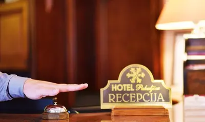 a hand pointing to a hotel palestine sign on a table at Hotel Pahuljica in Vlasic