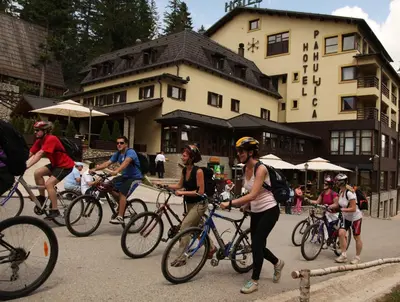 a group of people riding bikes down a street at Hotel Pahuljica in Vlasic