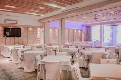 a banquet hall with white tables and white chairs at Hotel Pahuljica in Vlasic