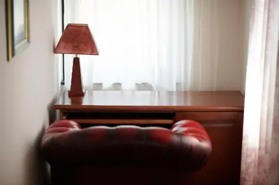 a desk with a lamp and a red leather chair at Hotel Pahuljica in Vlasic