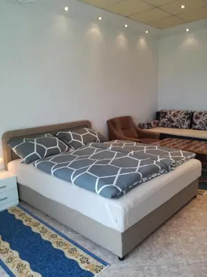 a bedroom with a large bed and a couch at Prenociste Orhideja in Odžak