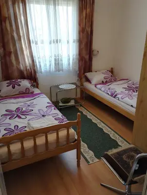 a bedroom with two beds and a window at Prenociste Orhideja in Odžak