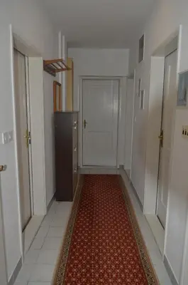 a hallway with a door and a red rug at Prenociste Orhideja in Odžak