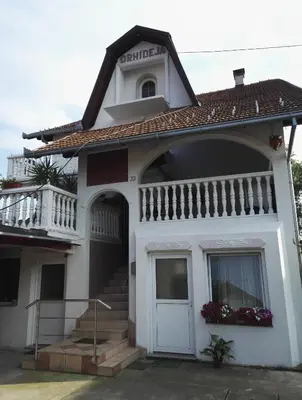 a white house with a white door and a balcony at Prenociste Orhideja in Odžak