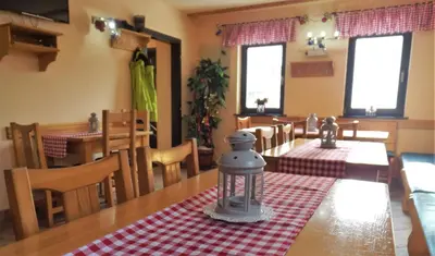 a dining room with a table with a red and white checkered table cloth at Apartments BellaMonte Vlašić in Vlasic