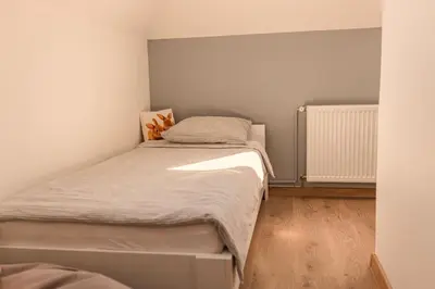 a small bedroom with a bed and a radiator at Downtown Apartment Travnik in Travnik