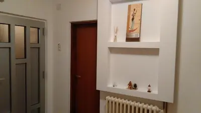 a room with a white wall with shelves and a radiator at Apartman Mima in Banja Luka