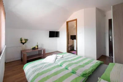 a bedroom with a large bed and a table at Guesthouse Vila Puzic in Banja Luka