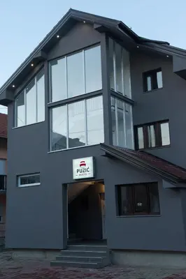 a large gray building with a sign on it at Guesthouse Vila Puzic in Banja Luka
