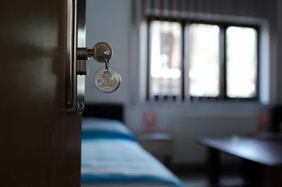 a room with a door with a bed and a window at Guesthouse Vila Puzic in Banja Luka