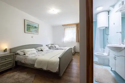 a bedroom with a bed and a sink at Lake House Bebić in Kupres