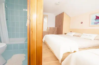 a bedroom with a bed and a bath tub and a bed and a bathroom at Lake House Bebić in Kupres