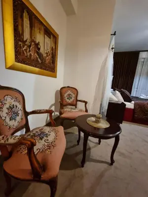 a living room with chairs and a table and a bed at Apartmani Li in Livno