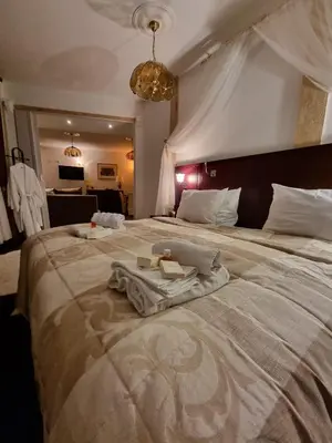 a large bed with a robe on top of it at Apartmani Li in Livno
