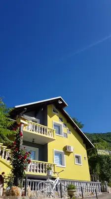 a yellow house with bikes parked in front of it at Pansion Renata in Prozor