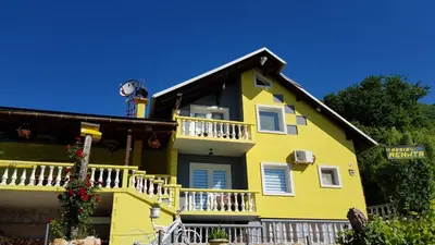 a yellow house with a balcony at Pansion Renata in Prozor