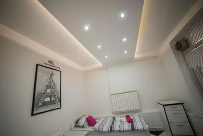 a bedroom with a bed and a picture of the eiffel tower at Apartman Hitno in Tuzla