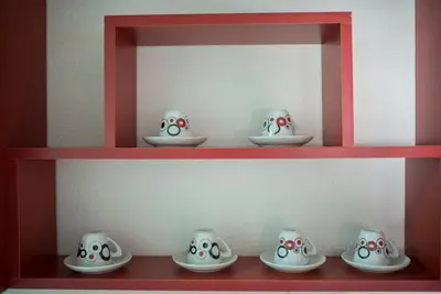 a red shelf with bowls and plates on it at Apartman Hitno in Tuzla