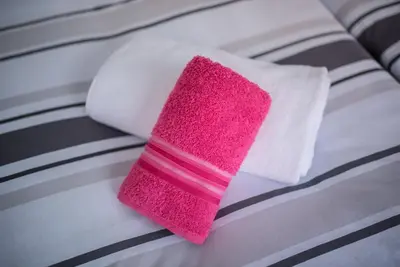 a pink cleaning sponge sitting on top of a bed at Apartman Hitno in Tuzla