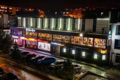a building with cars parked in a parking lot at night at Hotel Kakanj in Kakanj