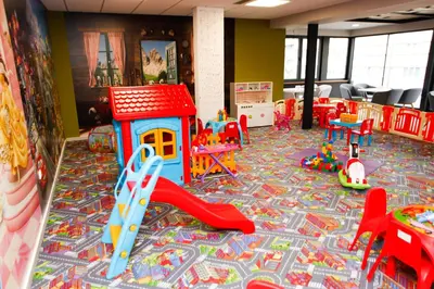 a childrens play room with a playground with a slide at Hotel Kakanj in Kakanj
