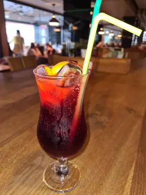 a drink with a yellow straw sitting on a table at Hotel Kakanj in Kakanj