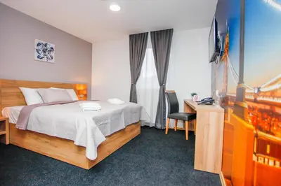 a bedroom with a bed and a desk and a television at Hotel Kakanj in Kakanj