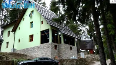 a house with a black car parked in front of it at Villa Tiha noc in Vlasic