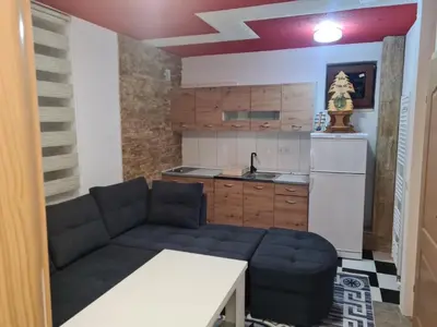 a living room with a couch and a kitchen at Villa Tiha noc in Vlasic