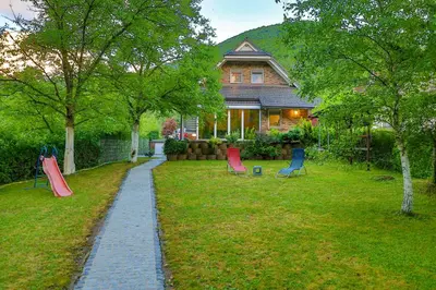a house with a garden with chairs in the yard at Holiday Home Villa Sara in Bihać