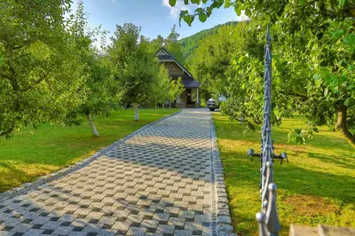 a cobblestone path in a park with a building at Holiday Home Villa Sara in Bihać