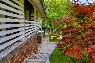 a walkway next to a house with red flowers at Holiday Home Villa Sara in Bihać