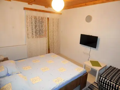 a bedroom with a bed and a flat screen tv at Smreka Vlašić in Vlasic