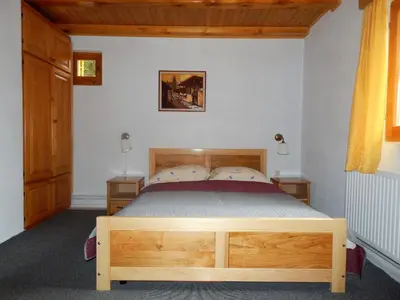 a bedroom with a wooden bed and two lamps at Smreka Vlašić in Vlasic