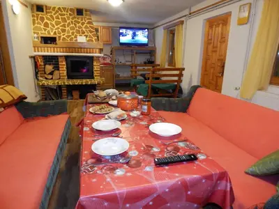 a living room with a table with a red table cloth at Smreka Vlašić in Vlasic