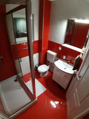 a red bathroom with a toilet and a sink at KAĆA APARTMANI 1 in Banja Luka