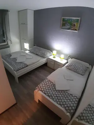 two beds in a small room with two lamps at KAĆA APARTMANI 1 in Banja Luka
