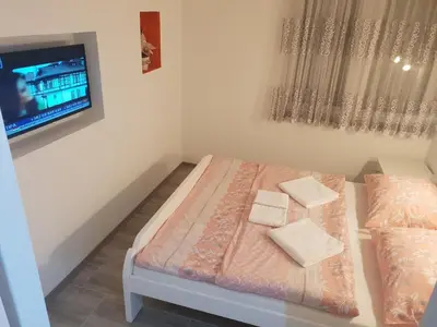 a small room with a bed and a flat screen tv at KAĆA APARTMANI 1 in Banja Luka