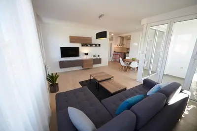 a living room with a blue couch and a table at Modern luxurious apartment in Banja Luka