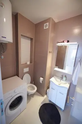 a bathroom with a washing machine and a sink at Modern luxurious apartment in Banja Luka
