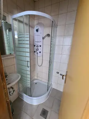 a shower with a glass door in a bathroom at Apartments and Rooms Ski in Vlasic
